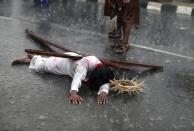 A man dressed as Jesus Christ performs during a re-enactment of the death of Jesus Christ, on Good Friday in Lagos April 18, 2014.