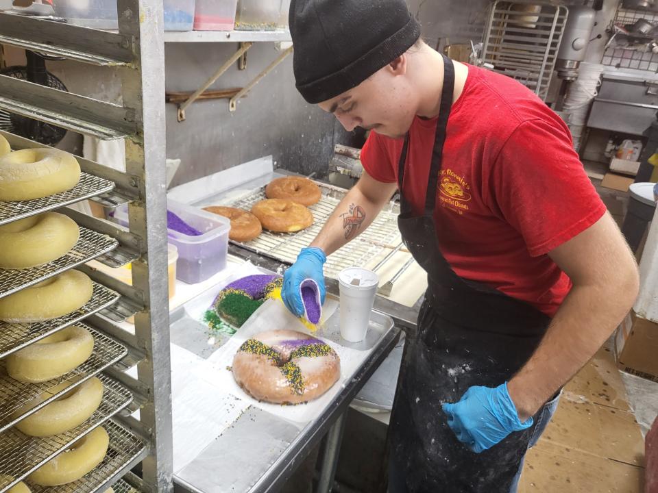 Michael Lirette adds sprinkles to small king cakes at Mr. Ronnie's Famous Hot Donuts in Houma on Monday, Jan. 30, 2023.