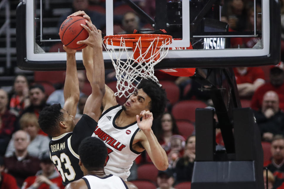 Louisville forward Jordan Nwora (33) blocks the shot of Wake Forest forward Ody Oguama (33) during the first half of an NCAA college basketball game Wednesday, Feb. 5, 2020, in Louisville, Ky. (AP Photo/Wade Payne)