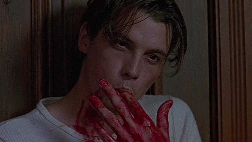 Billy Loomis licks blood off of his fingers in a scene from Scream.