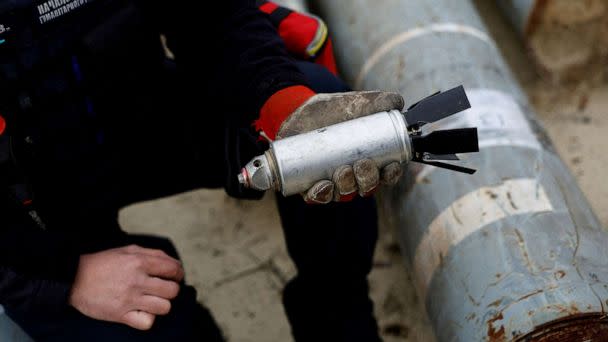 PHOTO: Ukrainian military serviceman Igor Ovcharruck holds a defused cluster bomb from an MSLR missile that a Ukrainian munitions expert said did not explode on impact, in the region of Kharkiv, Ukraine, Oct. 21, 2022. (Clodagh Kilcoyne/Reuters, FILE)
