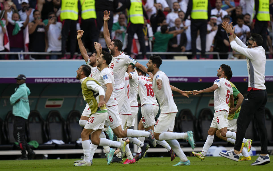 Iran's players celebrate at the end of the World Cup group B soccer match between Wales and Iran, at the Ahmad Bin Ali Stadium in Al Rayyan , Qatar, Friday, Nov. 25, 2022. (AP Photo/Pavel Golovkin)