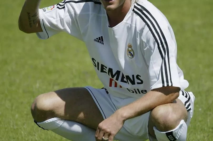 David Beckham shows off his new shirt at the Real Madrid press conference announcing his signing to Real Madrid at the Pabellon Raimundo Saporta, on July 2 in Madrid, Spain