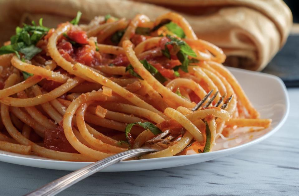 Bucatini amatriciana pasta with basil fork