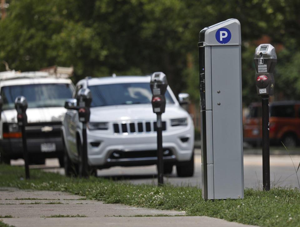 A pay-by-plate parking kiosk stands among more conventional parking meters on Park Street in 2020.