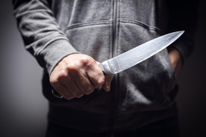 Criminal with knife weapon threatening to stab