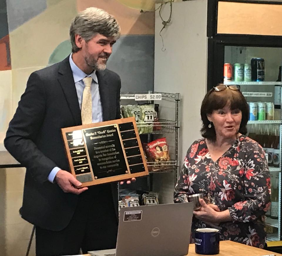 Augusta Bar Association President Duane Barron presents attorney Angela Whitesell with a humanitarian award Tuesday.
