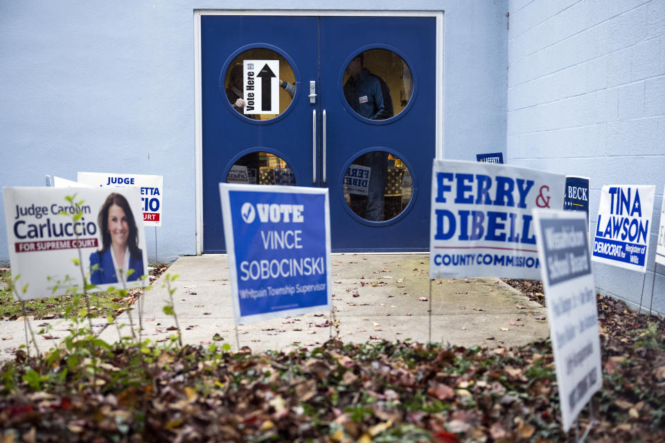 Officials adjust a sign on Election Day at the Wissahickon Valley Public Library in Blue Bell, Pa. on Tuesday, Nov. 7, 2023. (AP Photo/Joe Lamberti)