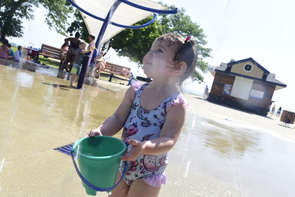 Calliegh VanBranda, 2, fills up her bucket with water during a hot morning at the splashpad in Lakeside Park in Port Huron on Wednesday, June 15, 2022.