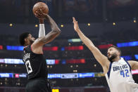 Los Angeles Clippers forward Paul George, left, shoots as Dallas Mavericks forward Maxi Kleber defends during the first half in Game 2 of an NBA basketball first-round playoff series Tuesday, April 23, 2024, in Los Angeles. (AP Photo/Mark J. Terrill)