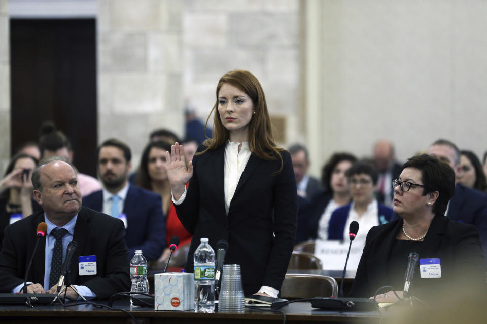 FILE- In this Dec. 4, 2018 file photo, Katie Brennan, the chief of staff at the New Jersey Housing and Mortgage Finance Agency, raises her hand as she is sworn-in to testify before the Select Oversight Committee at the Statehouse, in Trenton, N.J. On Wednesday, Jan. 23, 2019, the Middlesex County Prosecutor's office said that it would not be filing charges against Albert Alvarez, whom Brennan accused of sexually assaulting her in 2017, when they were both working to get Gov. Phil Murphy elected, citing "a lack of credible evidence." (AP Photo/Mel Evans, File)