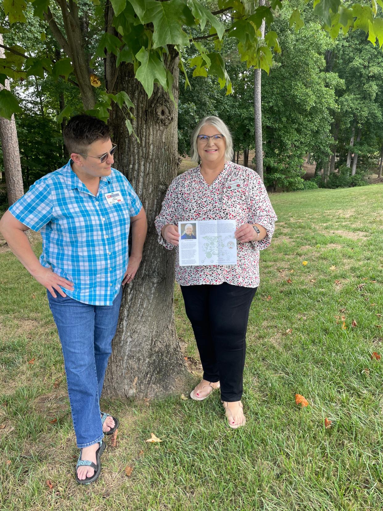 Anne Eskridge, member of the Dotty Leatherwood Memorial Garden Planning Committee, holds up a brochure with details on a proposed memorial garden while Julie Flowers, with the NC Cooperative Extension Office, looks on. Several groups have come together to plan the garden which will be located near the LeGrand Center.