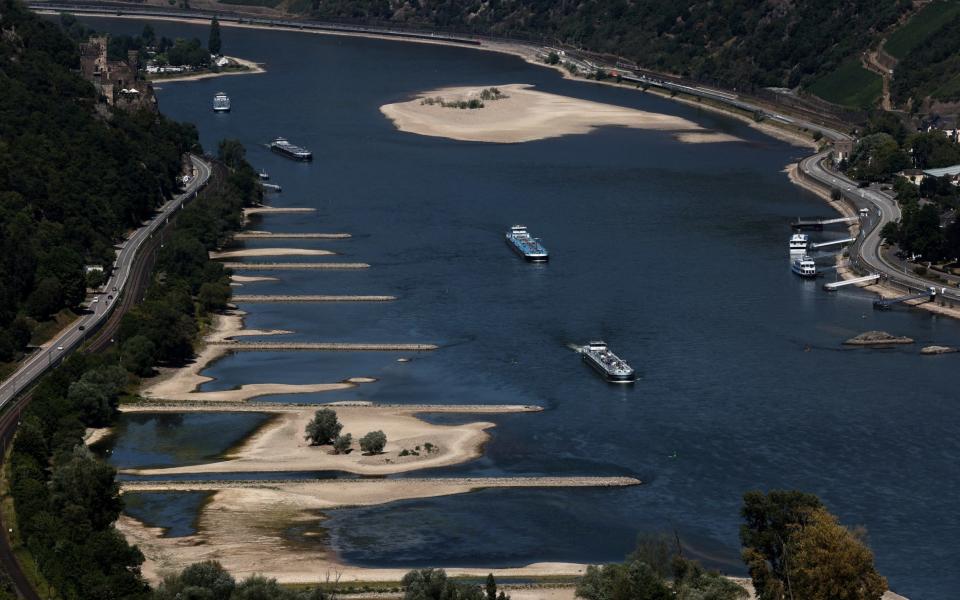 Transport vessels cruise past the partially dried riverbed of the Rhine river in Bingen, Germany - WOLFGANG RATTAY/REUTERS