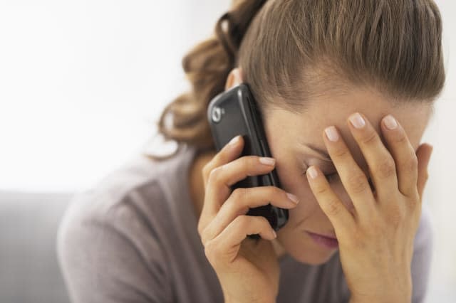 Stressed young woman talking mobile phone