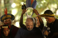 FILE - Brazil's former president who is running for reelection, Luiz Inacio Lula da Silva, receives a headdress from Assurini Indigenous people during a meeting with traditional populations from the Amazon in Belem, Para state, Brazil, Sept. 2, 2022. Despite the smoke clogging the air of entire Amazon cities, state elections have largely ignored environmental issues. Far-right President Jair Bolsonaro is seeking a second four-year term against leftist da Silva, who ruled Brazil between 2003 and 2010. (AP Photo/Raimundo Pacco, File)