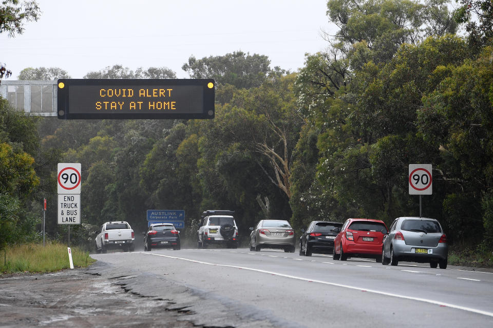 Cars drive past a Covid-19 alert sign on Mona Vale road at Belrose on Sydney's northern beaches, Saturday, December 19, 2020