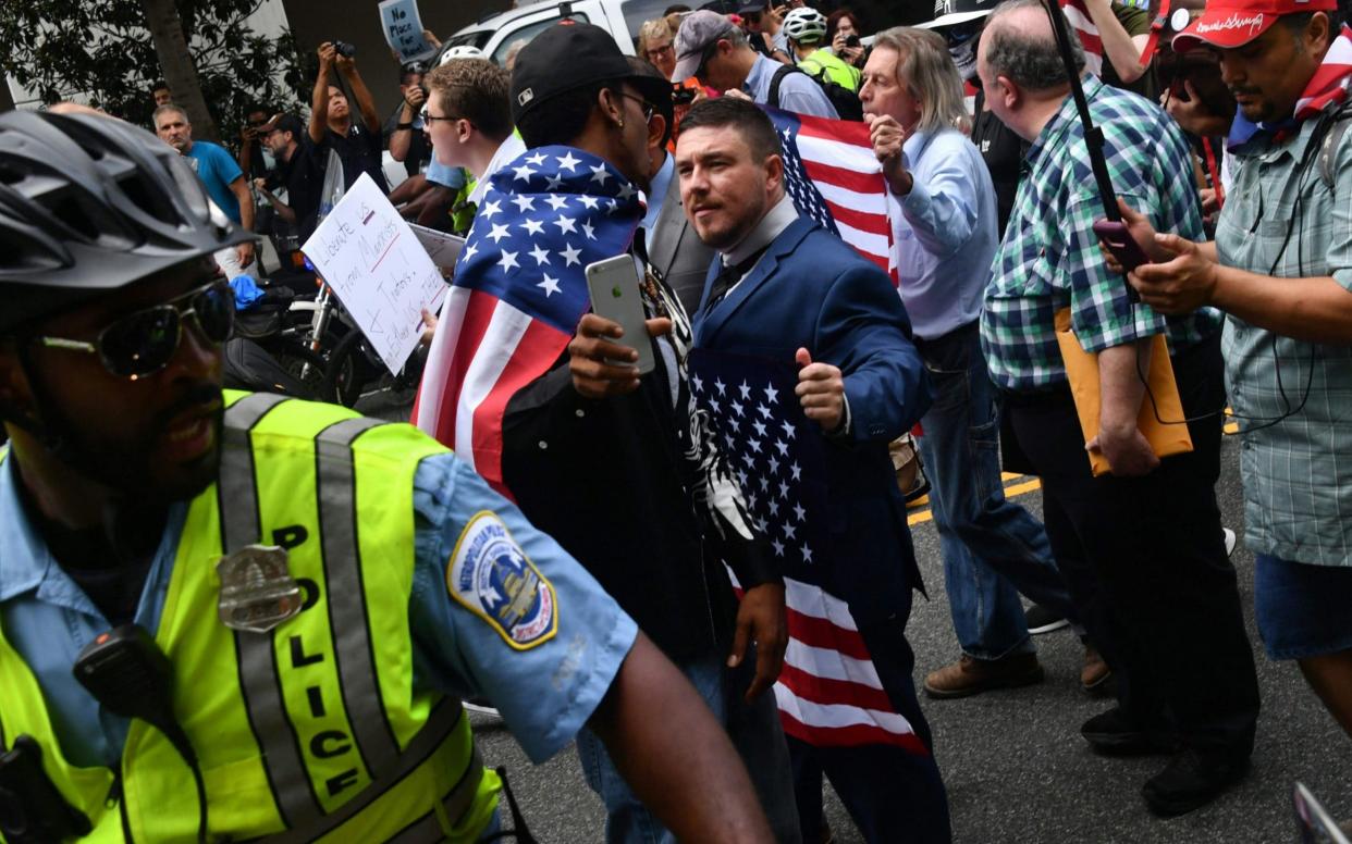 Jason Kessler, escorted by police during his August 12 rally outside the White House - AFP