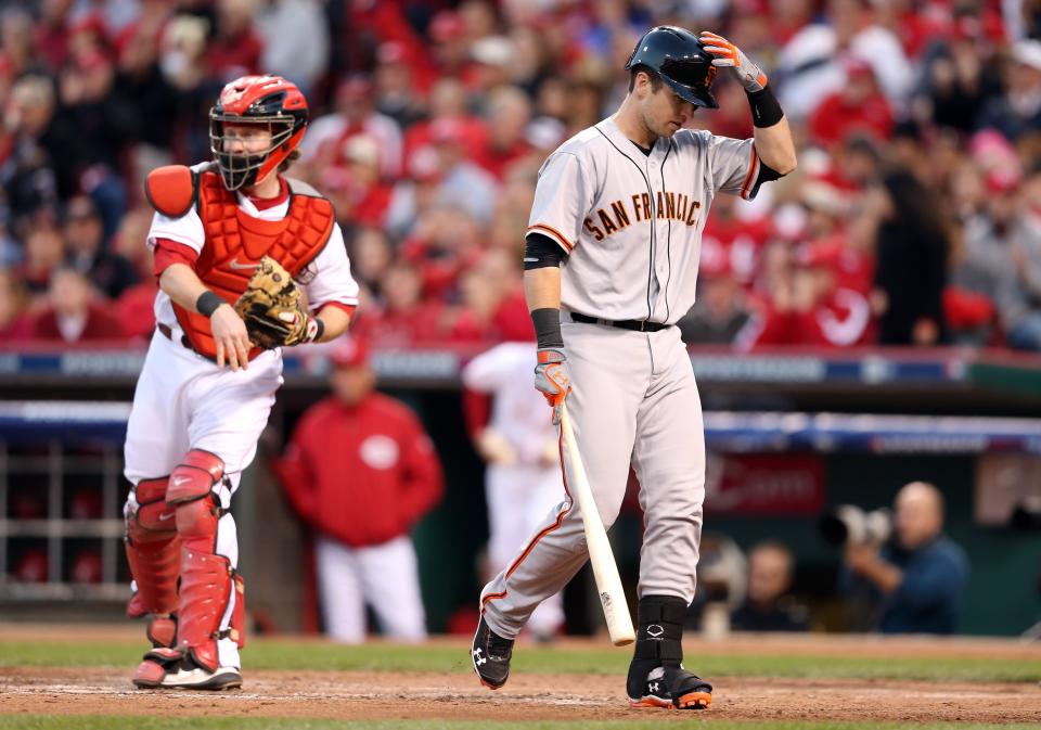 Buster Posey #28 of the San Francisco Giants reacts after striking out in the fourth inning as Ryan Hanigan #29 of the Cincinnati Reds throws the ball back to the pitcher in Game Three of the National League Division Series at the Great American Ball Park on October 9, 2012 in Cincinnati, Ohio. (Photo by Andy Lyons/Getty Images)