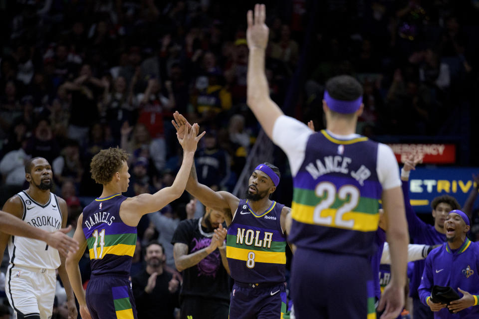 New Orleans Pelicans forward Naji Marshall (8) celebrates a 3-point basket with guard Dyson Daniels (11) next to Brooklyn Nets forward Kevin Durant, left, and Pelicans forward Larry Nance Jr. (22) in the first half of an NBA basketball game in New Orleans, Friday, Jan. 6, 2023. (AP Photo/Matthew Hinton)