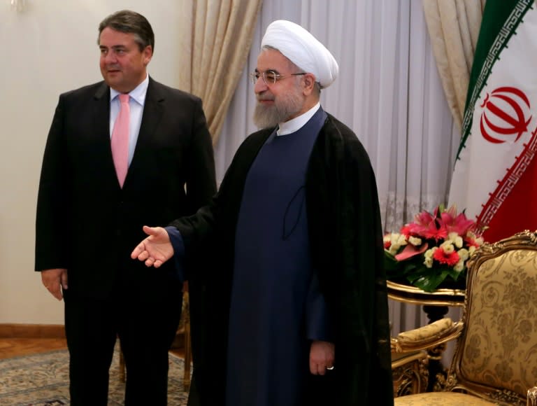 Iranian President Hassan Rouhani stands next to German Economy and Energy Minister Sigmar Gabriel (L) as he welcomes other officials from the German delegation in Tehran, on July 20, 2015