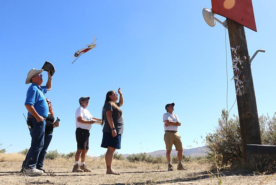 Members of the pylon 8 judging crew watch as racing planes race by during the final National Championship Air Races in Reno on Sept. 14, 2023.