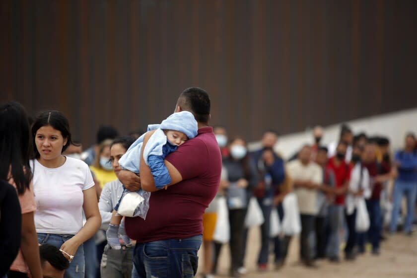 Migrants who had crossed the Rio Grande river into the U.S. wait to be processed by Border Patrol agents in Eagle Pass, Texas, Friday, May 20, 2022. The Eagle Pass area has become increasingly a popular crossing corridor for migrants, especially those from outside Mexico and Central America, under Title 42 authority, which expels migrants without a chance to seek asylum on grounds of preventing the spread of COVID-19. A judge was expected to rule on a bid by Louisiana and 23 other states to keep Title 42 in effect before the Biden administration was to end it Monday. (AP Photo/Dario Lopez-Mills)