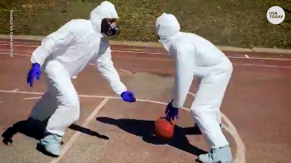 Teenagers in New York wear hazmat suits playing basketball during the coronavirus lockdown
