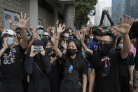 Supporters of Hong Kong activist Edward Leung, hold up their hands to represent the protesters' five demands outside the High Court in Hong Kong, Wednesday, Oct. 9, 2019. Last year, Leung was sentenced to six years in prison for his part in a violent nightlong clash with police over illegal street food hawkers two years ago. (AP Photo/Kin Cheung)
