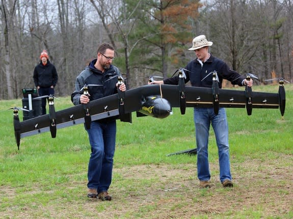 NASA engineers David North (left) and Bill Fredericks (right) carry the "Greased Lightning" drone before one of its flight tests.