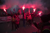 Protesters pose for pictures with flares during a demonstration in Marseille, southern France, Friday, Jan. 24, 2020. French unions are holding last-ditch strikes and protests around the country Friday as the government unveils a divisive bill redesigning the national retirement system. (AP Photo/Daniel Cole)