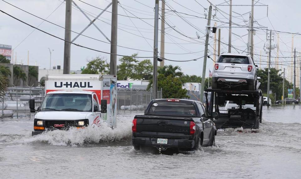 Cars and trucks drive on flooded streets around Northwest 63rd Street and 73rd Avenue in West Miami-Dade on Wednesday.