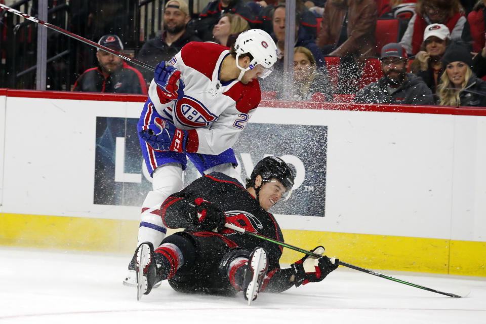 Montreal Canadiens' Ryan Poehling (25) collides with Carolina Hurricanes' Haydn Fleury (4) during the first period of an NHL hockey game in Raleigh, N.C., Tuesday, Dec. 31, 2019. (AP Photo/Karl B DeBlaker)