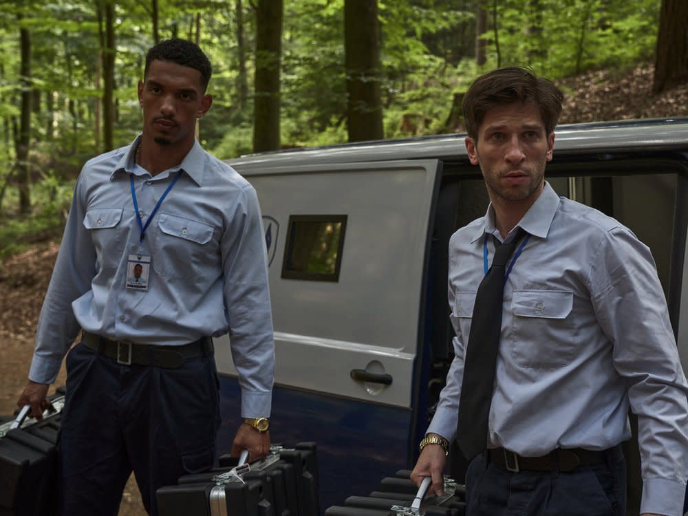 "Der Millionen Raub": Omar Abdallah (Karim Ben Mansur) und Zlatko Petrovic (Slavko Popadić) stehen mit jeweils zwei Koffern in der Hand vor einem Geldtransporter. (Bild: ZDF/Thomas Leidig)