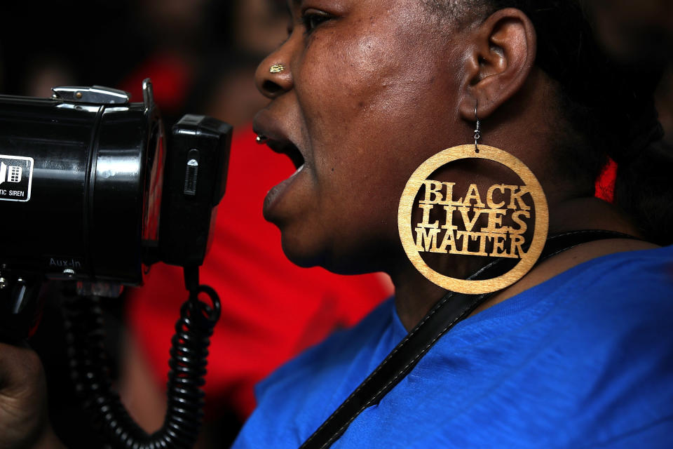 A Black Lives Matter protester uses a bullhorn during a demonstration in front of the offices of District Attorney Anne Marie Schubert.