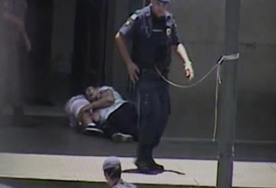 In this frame grab taken from a security camera provided by Campinas City Hall, two people shot by a gunman lie wounded at the entrance of the Metropolitan Cathedral, in Campinas, Brazil, Tuesday, Dec. 11, 2018. A man opened fire inside the cathedral in southern Brazil after Mass on Tuesday, killing four and leaving others injured before turning a gun on himself, authorities said. (Campinas City Hall via AP)