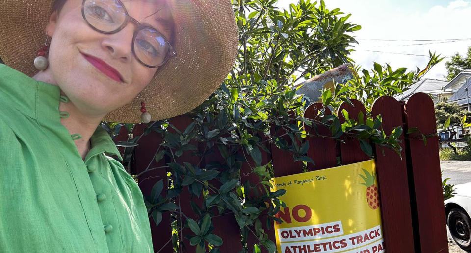 A photo of Greens MP for South Brisbane next to a sign discouraging an olympics athletics track at Kangaroo Point&#x002019;s Raymond Park.