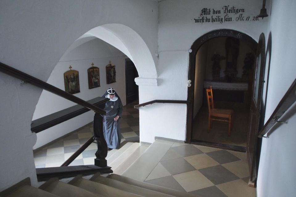 CORRECTS DETAILS ABOUT THE ABBEY In this Dec. 6, 2016 photo Sister Apollonia walks through the abbey in Altomuenster, Germany. The impending dissolution of a 15th-century monastery in Bavaria is pitting scholars against Catholic church officials. The library in Altomuenster Abbey, accessible only to the monastery’s nuns for more than five centuries, contains precious illuminated manuscripts and other treasures. Scholars worry the “holy grail” for Bridgettine Order research could be damaged, broken up or sold off before it can be catalogued and studied. (AP Photo/David Rising)