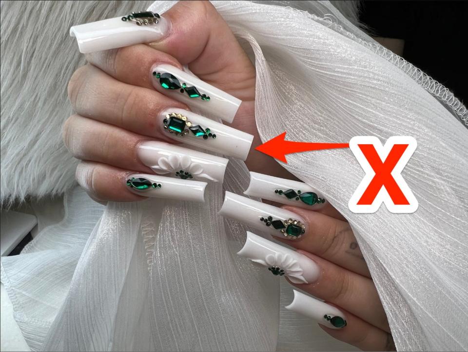 An X pointing at white nails.