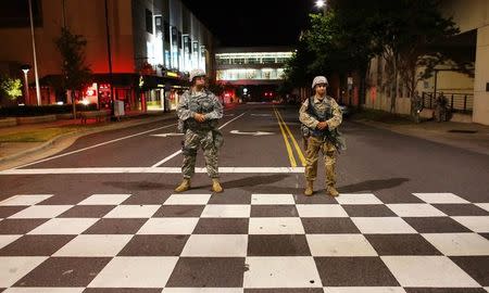 National Guard soldiers watch as protesters march during another night of protests over the police shooting of Keith Scott in Charlotte, North Carolina, U.S. September 23, 2016. REUTERS/Mike Blake