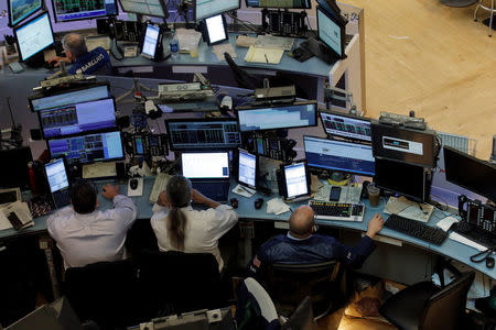 Traders work at desks on the floor of the New York Stock Exchange (NYSE) in New York City, U.S., August 23, 2016. REUTERS/Brendan McDermid