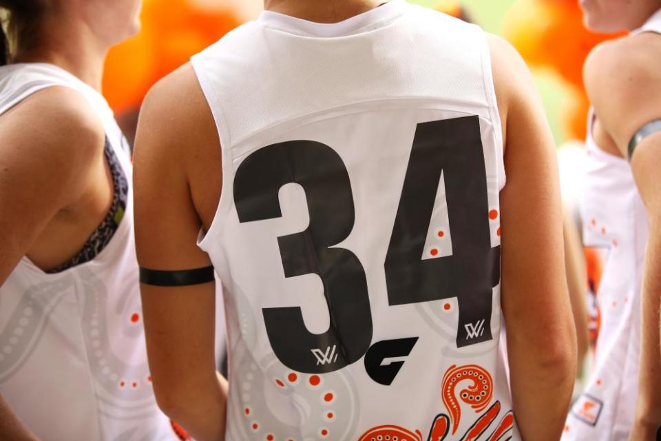 Giants players wearing number 34 jerseys in memory of Jacinda Barclay watch on as their team mates prepare to take the field.