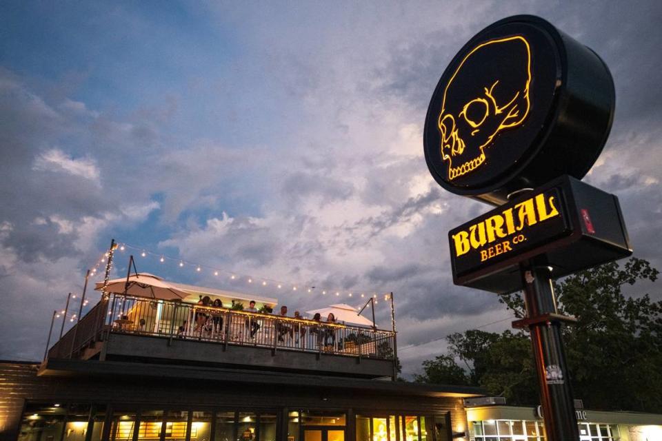 Patrons enjoy drinks on the rooftop bar at Burial Beer Co. in Plaza Midwood.