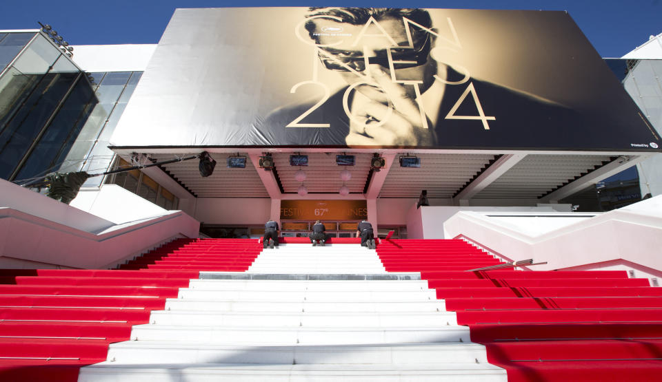 Workers prepare the red carpet on the stairs of the Palais des Festivals prior to the start of the 67th international film festival, Cannes, southern France on Wednesday, May 14, 2014. The festival runs from May 14th to May 25th. (AP Photo/Virginia Mayo)