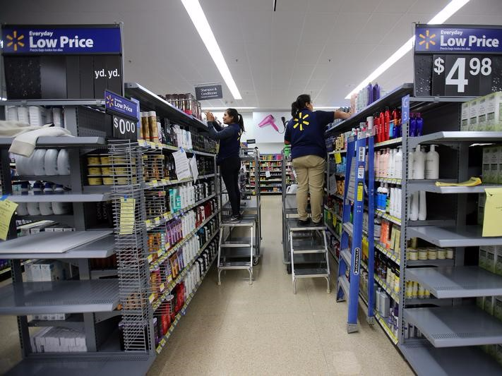 FILE PHOTO: Workers stock shelves in a newly built Walmart Super Center prior to its opening in Compton, California, U.S., January 10, 2017.  REUTERS/Mike Blake