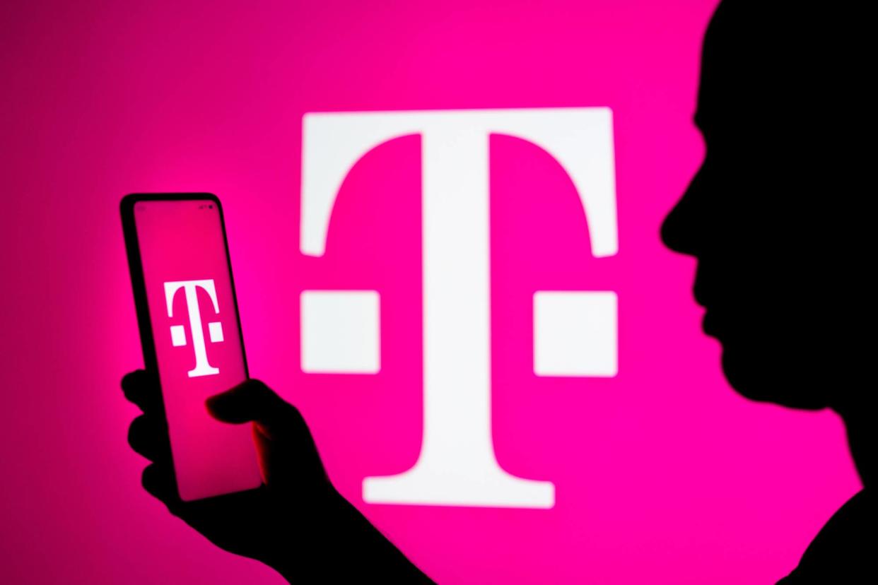  Woman holding phone with T-Mobile logo against pink background with T-Mobile logo 