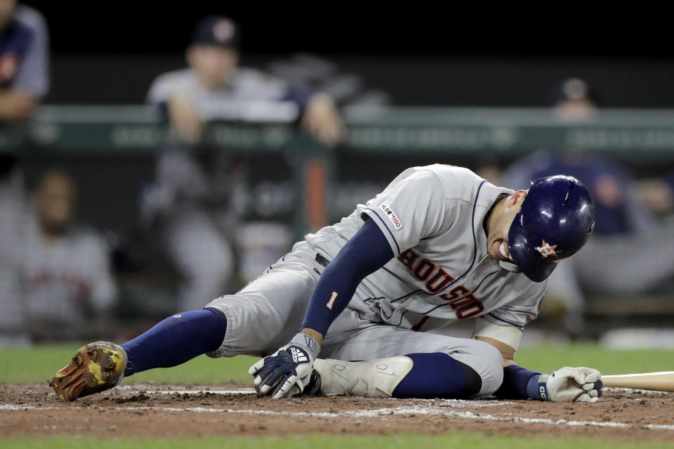 Houston Astros' Carlos Correa grabs his foot after fouling a pitch off it during the sixth inning of the team's baseball game against the Baltimore Orioles, Saturday, Aug. 10, 2019, in Baltimore. (AP Photo/Julio Cortez)