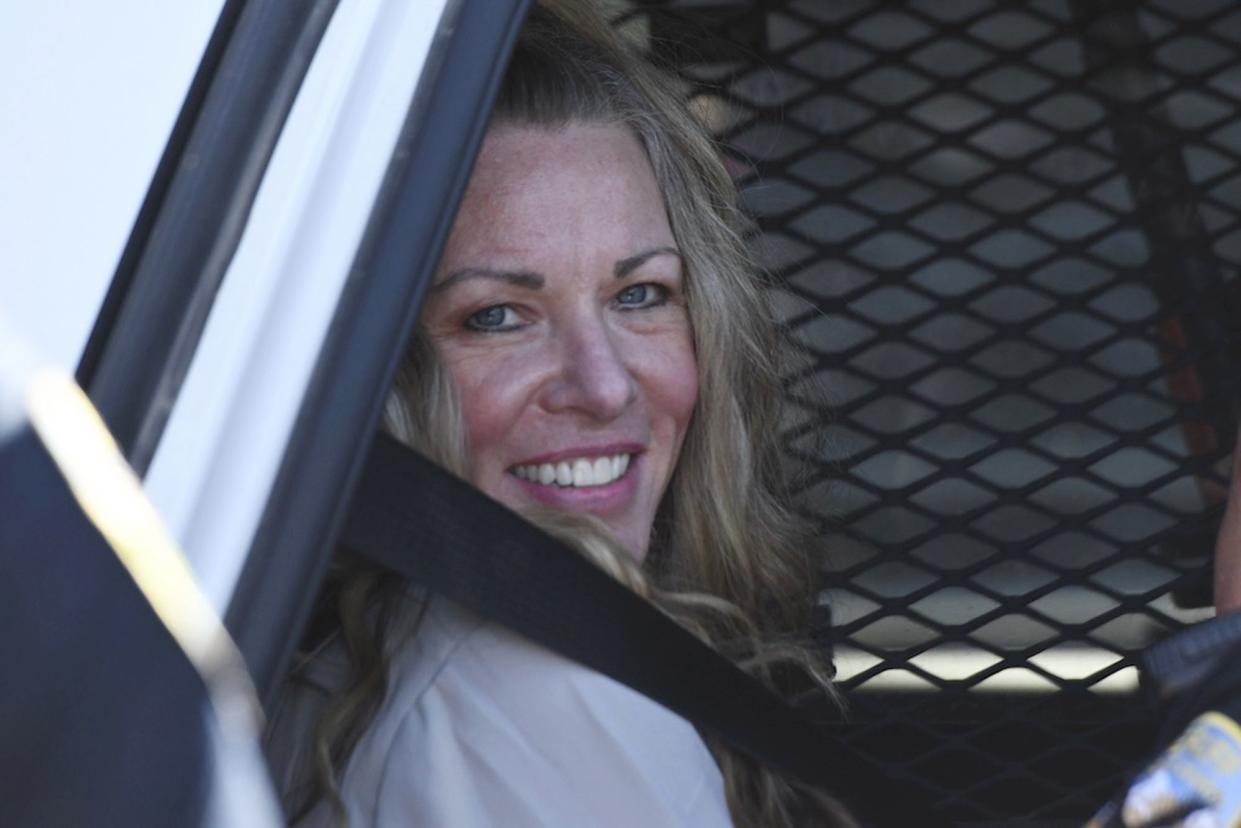 Lori Vallow smiles from the backseat of a police car after an Aug. 16 hearing in Idaho.