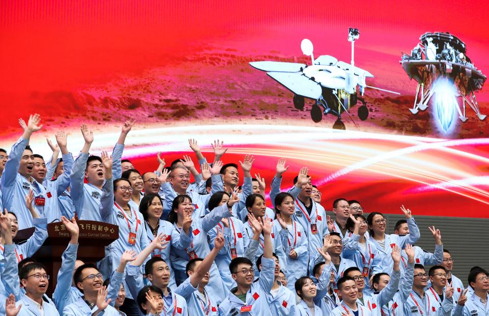 In this photo released by Xinhua News Agency, members at the Beijing Aerospace Control Center celebrate after China's Tianwen-1 probe successfully landed on Mars.