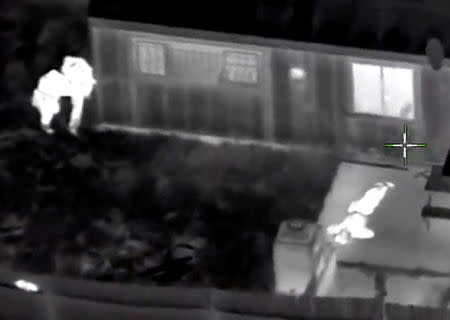 Stephon Clark, 22, is visible on the ground after two police officers (L) shot him, in this still image captured from police aerial video footage released by Sacramento Police Department, California, U.S., on March 21, 2018. Courtesy Sacramento Police Department/Handout via REUTERS