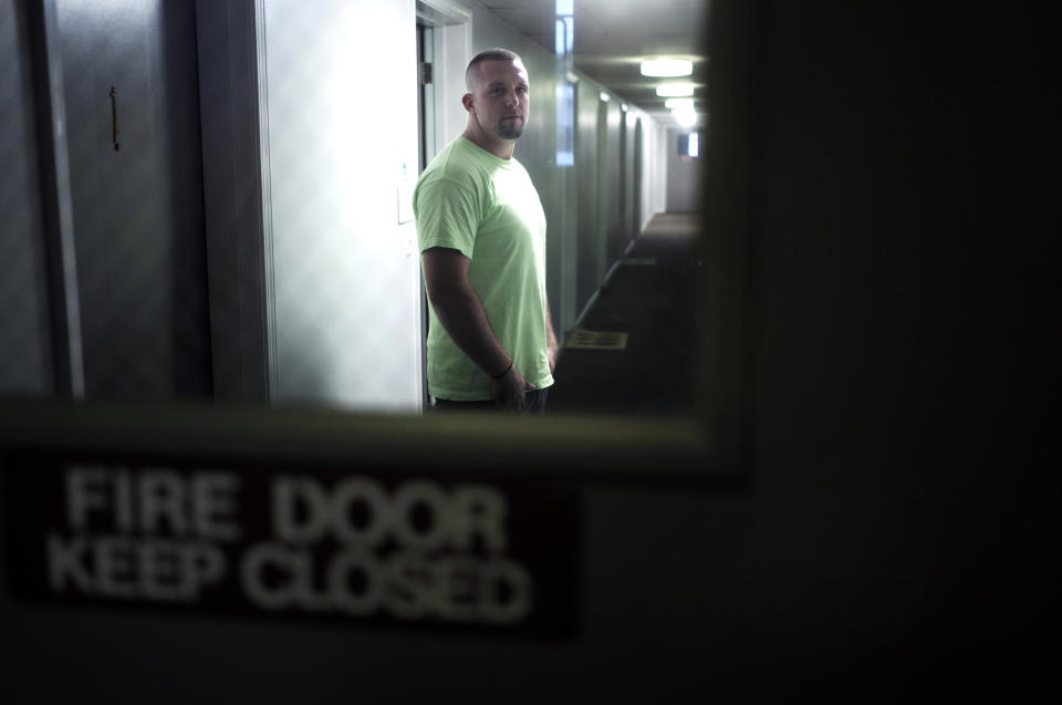 In this Monday, Oct. 1, 2018 photo, Michael Robinson, of North Reading, Mass., in recovery from heroin addiction, stands for a photo in a hallway outside his mother's apartment, in North Reading. Robinson recently became a union carpenter and has been working on building projects across the Boston area since. In Massachusetts, with Medicaid expansion already paying for opioid addiction treatment, emergency money from Congress goes largely toward recovery services. (AP Photo/Steven Senne)